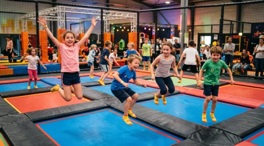 Groupe d'enfants sautant sur des trampolines interconnectés dans un parc de trampoline indoor